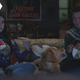 Kate and Clint wearing Christmas sweaters on the couch in a scene from Hawkeye.